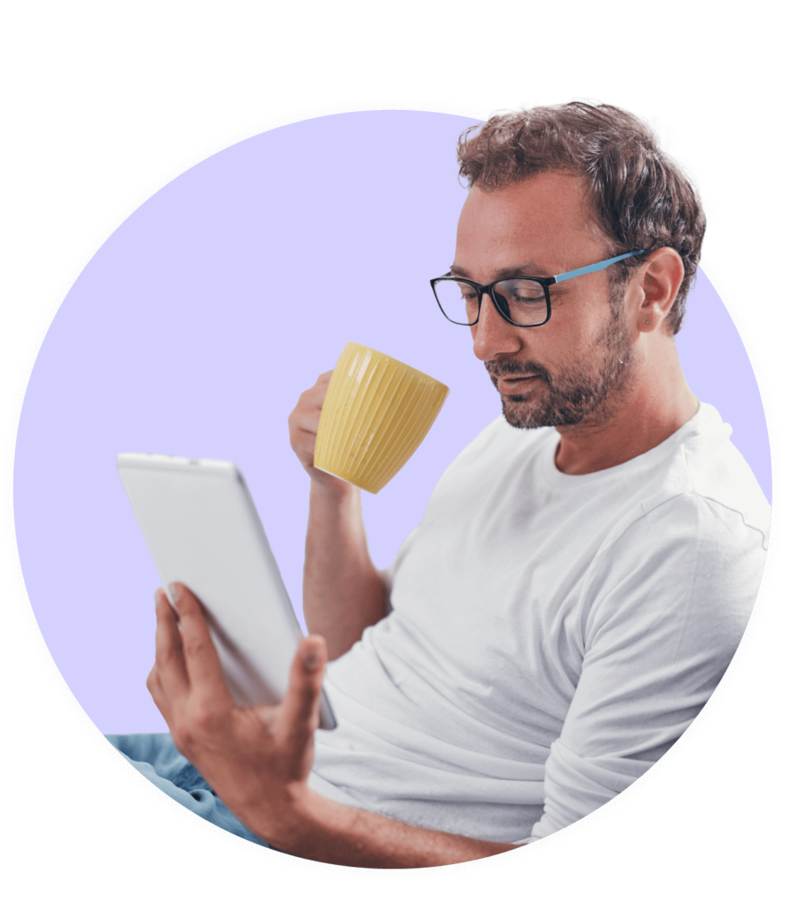Man looking at tablet while drinking coffee